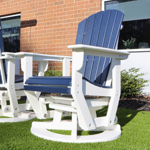 Blue and white Adirondack swivel glider chair on a grassy area with a brick building in the background.