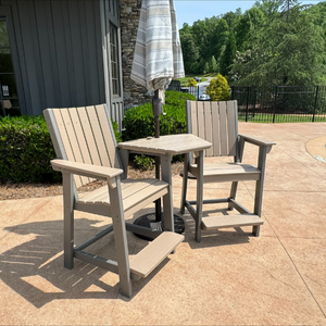Outdoor patio set with two counter chairs and a small table on a concrete patio.