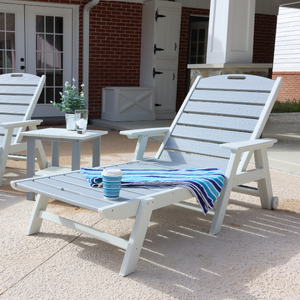 White outdoor lounge chair with a small table and decorative items on a patio.