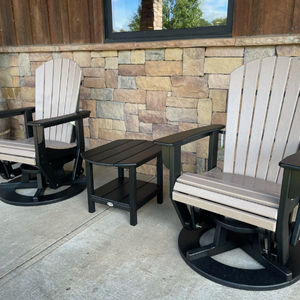 Two Adirondack swivel glider chairs with a small table on a patio.