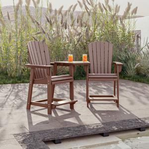 Two counter chairs with a small round table on a patio with plants in the background